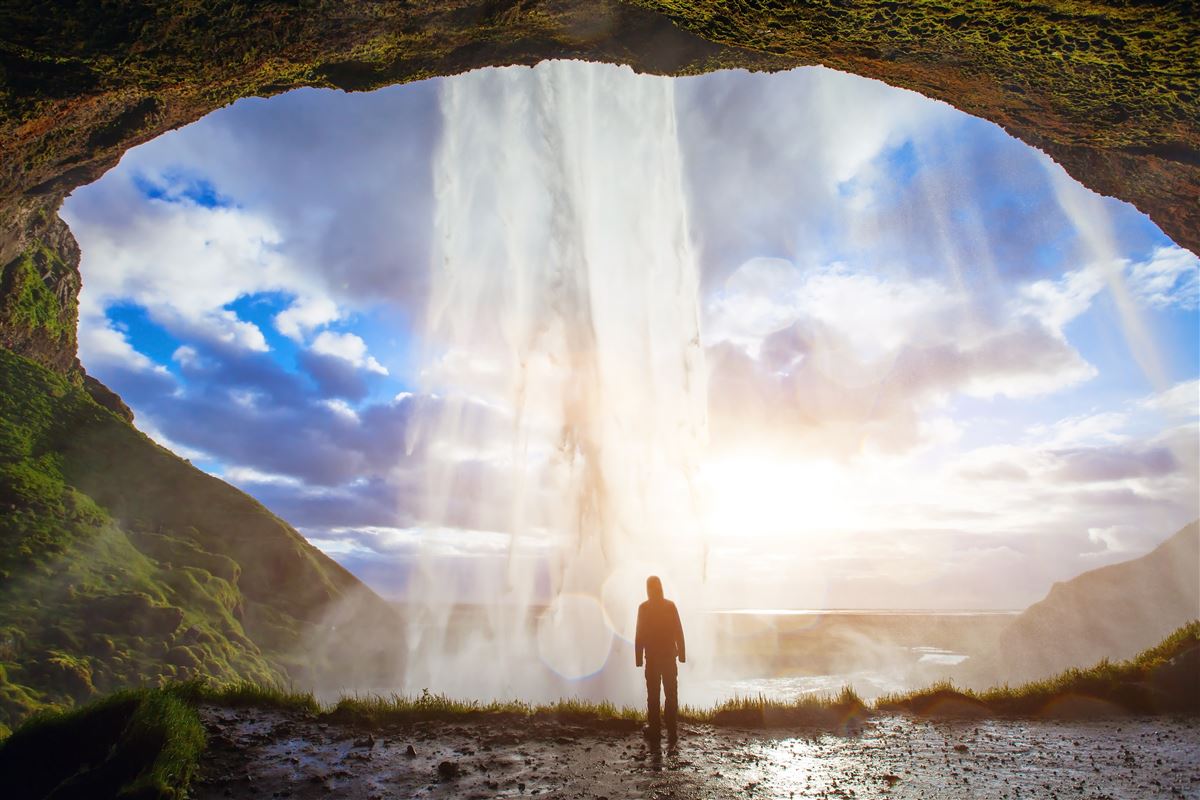 Man standing behind Seljalandsfoss on Soath Coast of Iceland